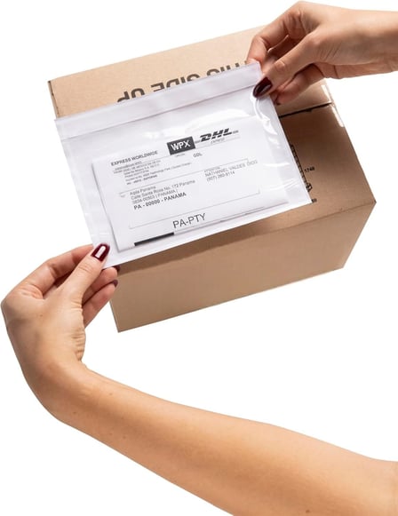Person placing clear packing slip pouch on a box