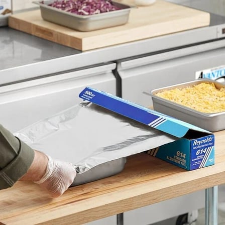 A Person Pulling Reynolds 18 Inches by 500 Feet Standard Aluminum Foil Roll.jpg